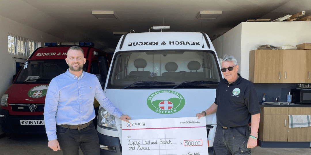 Two Men Standing in front of a Van Holding a Cheque 2