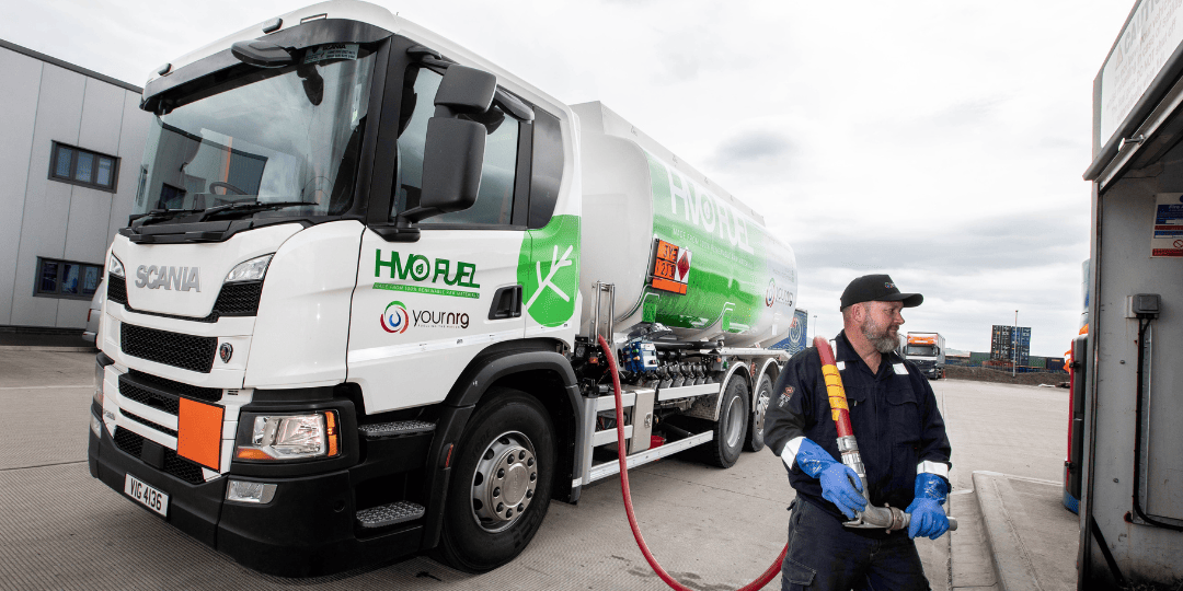 Man Holding Oil Hose in front of Tanker