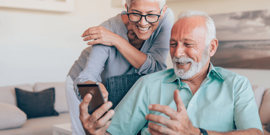 Couple Looking and Smiling at Mobile