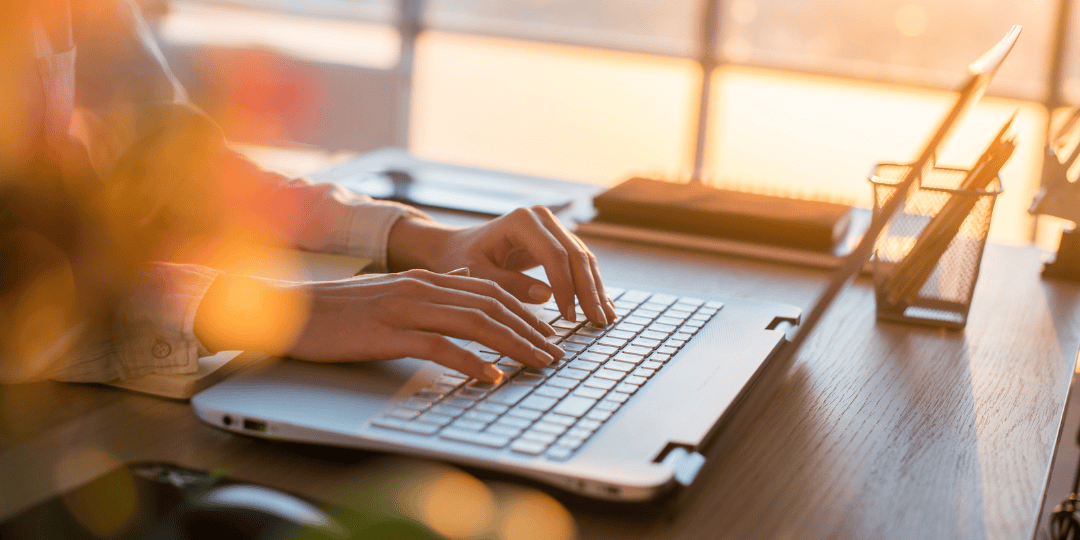 Woman Typing on Laptop at Desk